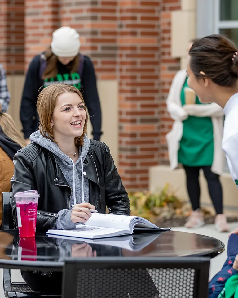 students communicating outdoors at table